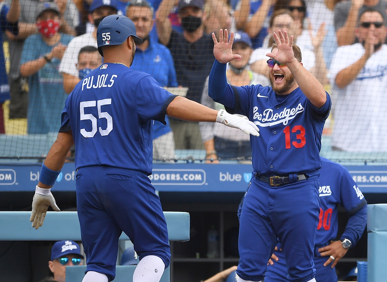 Los Angeles Dodgers' Max Muncy fixes his cap while wearing a new