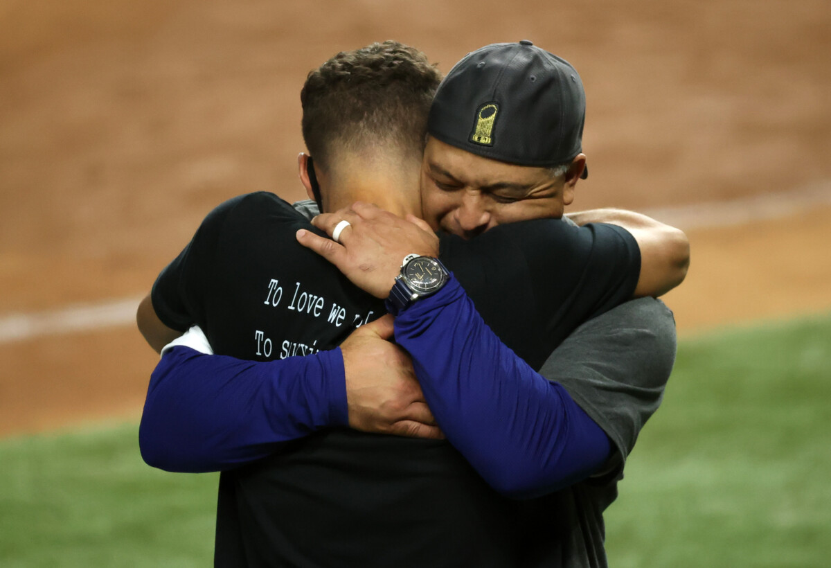 Los Angeles Dodgers manager Dave Roberts celebrating the 2020 World Series with his son, Cole Roberts.