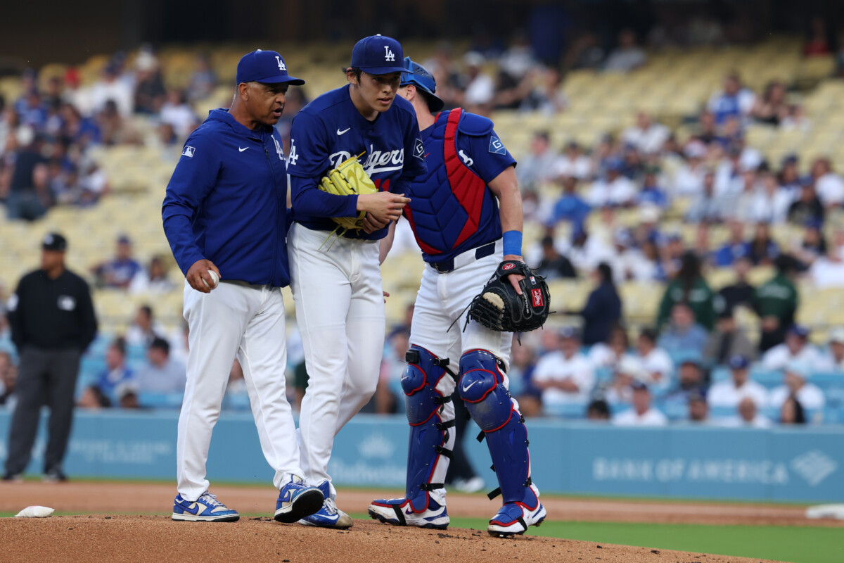Los Angeles Dodgers manager Dave Roberts (left) taking pitcher Roki Sasaki (middle) out from the game during the first inning against the Los Angeles Angels at Dodger Stadium.