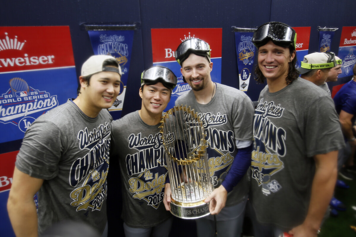 Los Angeles Dodgers two-way player Shohei Ohtani (17) and pitcher Yoshinobu Yamamoto (18) and pitcher Blake Snell (7) and pitcher Tyler Glasnow (31) celebrate with the Commissioner's Trophy in the clubhouse after defeating the Toronto Blue Jays in the 2025 MLB World Series at Rogers Centre.