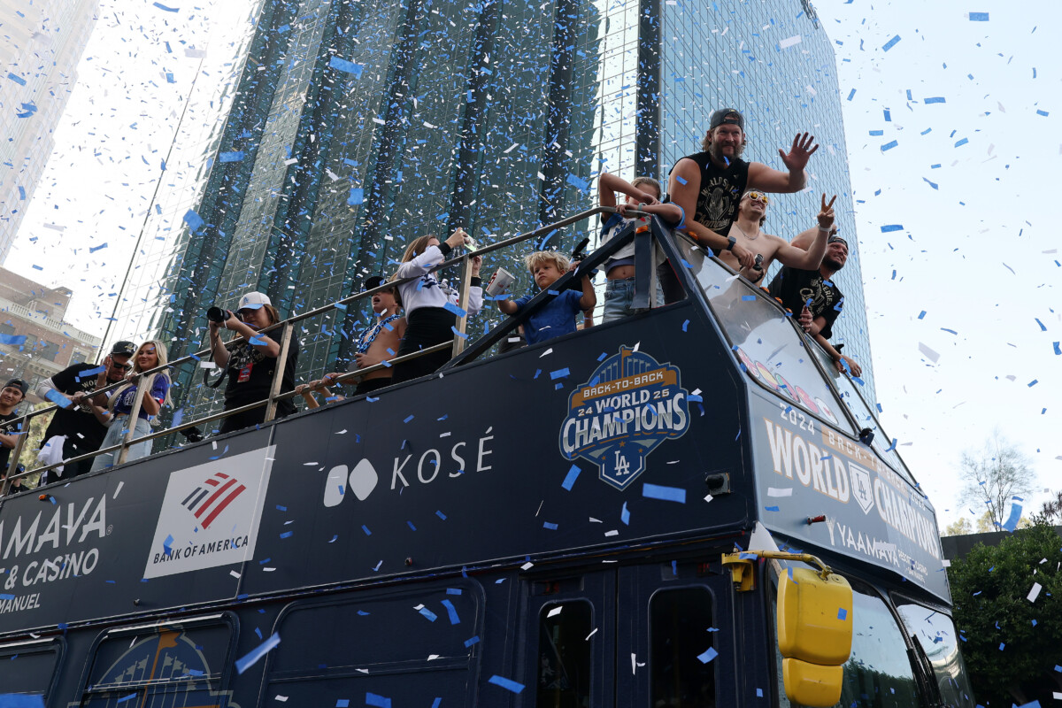 Los Angeles Dodgers players wave to the crowd during the World Series championship parade at downtown Los Angeles.