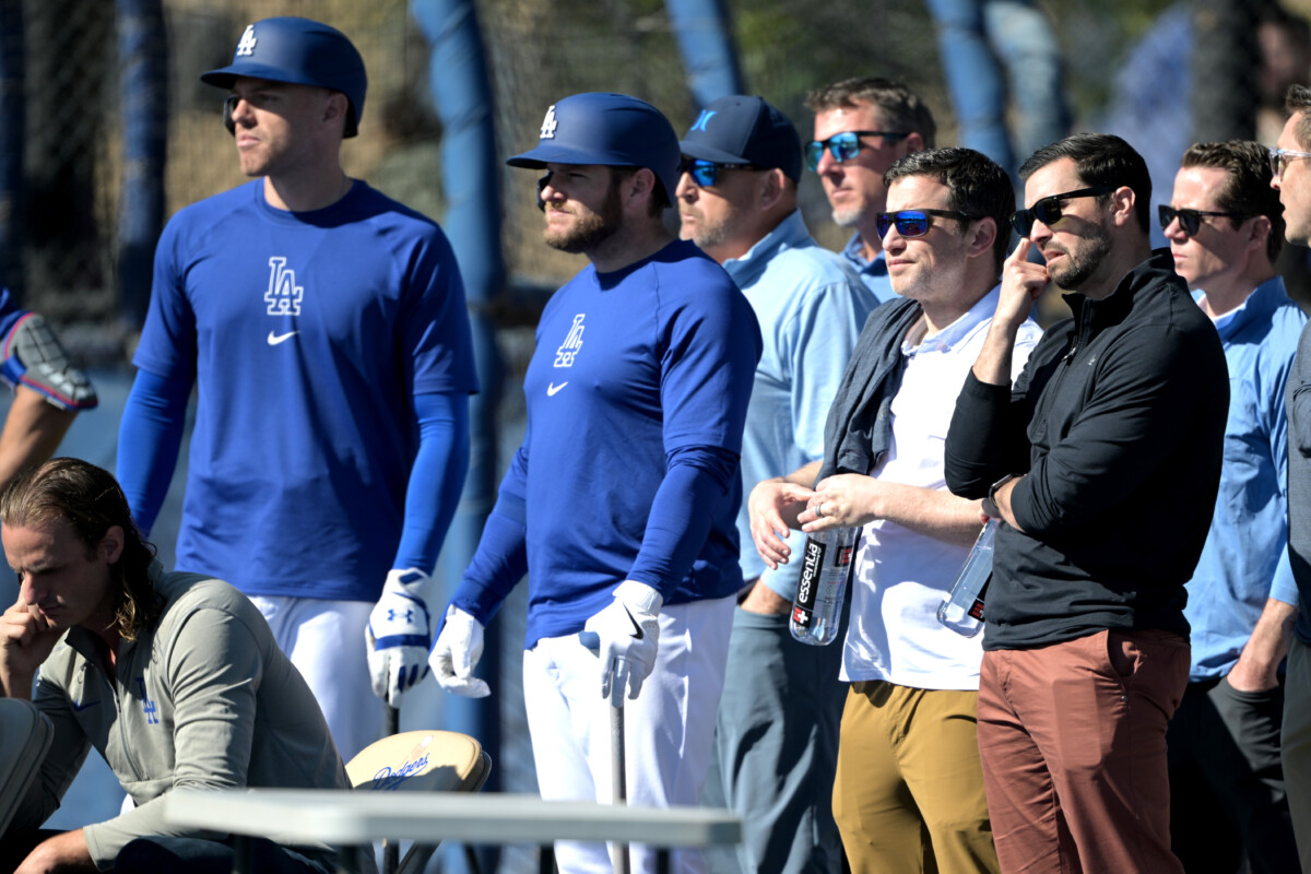 Feb 17, 2024; Glendale, AZ, USA; Los Angeles Dodgers first baseman Freddie Freeman (5), third baseman Max Muncy (13), president of baseball operations Andrew Friedman and executive vice president & general manager Brandon Gomes watch during batting practice at spring training at Camelback Ranch. Mandatory Credit: Jayne Kamin-Oncea-USA TODAY Sports