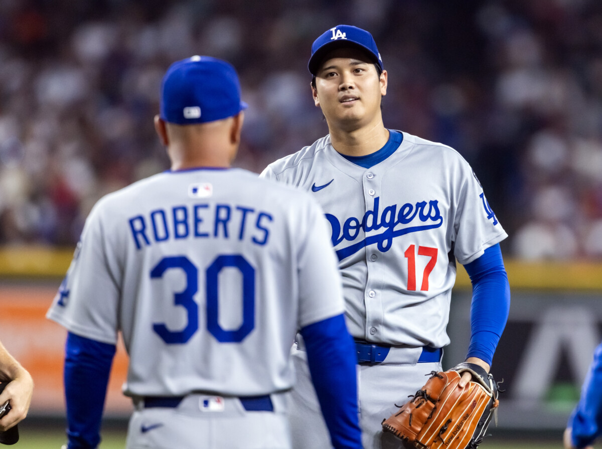 Sep 23, 2025; Phoenix, Arizona, USA; Los Angeles Dodgers pitcher/designated hitter Shohei Ohtani looks at manager Dave Roberts as he walks to the pitchers mound against the Arizona Diamondbacks at Chase Field. Mandatory Credit: Mark J. Rebilas-Imagn Images