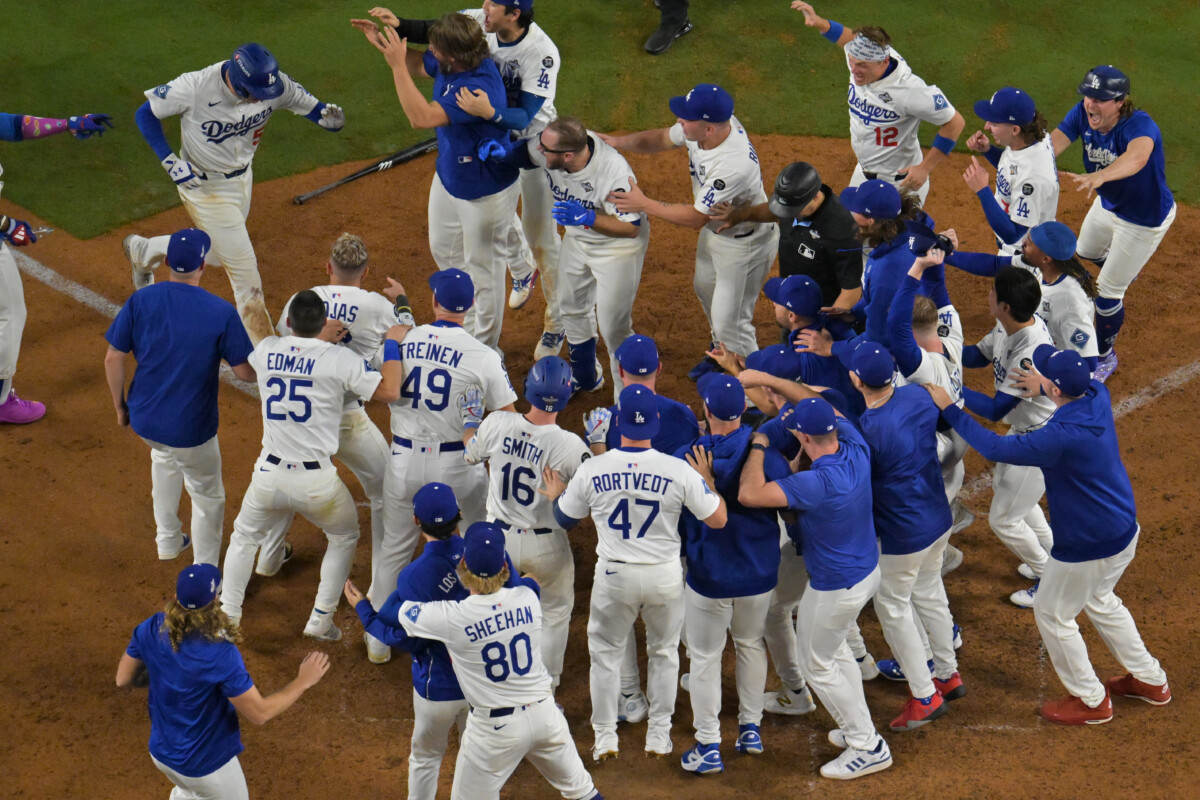 Oct 27, 2025; Los Angeles, California, USA; Los Angeles Dodgers first baseman Freddie Freeman (5) is mobbed as he crosses the plate after hitting a walk-off solo home run in the 18th inning during game three of the 2025 MLB World Series against the Toronto Blue Jays at Dodger Stadium. Mandatory Credit: Jayne Kamin-Oncea-Imagn Images