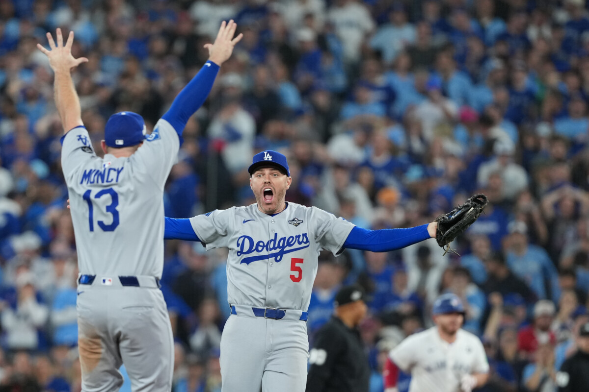 Nov 1, 2025; Toronto, Ontario, CAN; Los Angeles Dodgers first baseman Freddie Freeman (5) reacts with third baseman Max Muncy (13) after defeating the Toronto Blue Jays in the eleventh inning for game seven of the 2025 MLB World Series at Rogers Centre. Mandatory Credit: Nick Turchiaro-Imagn Images