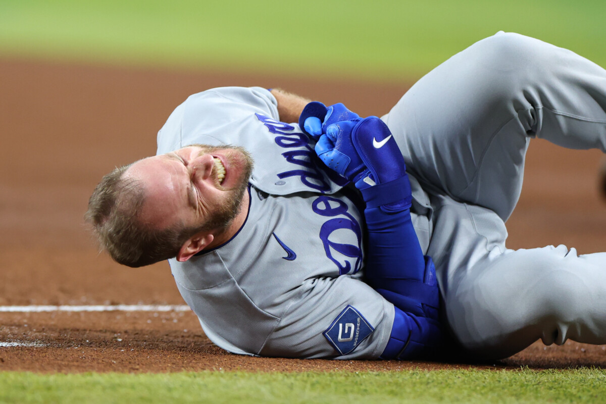 Jun 4, 2026; Phoenix, Arizona, USA; Los Angeles Dodgers third baseman Max Muncy (13) reacts with an apparent injury after colliding with Arizona Diamondbacks first baseman Ildemaro Vargas (not pictured) at first base in the fifth inning at Chase Field. Mandatory Credit: Anna Carrington-Imagn Images
