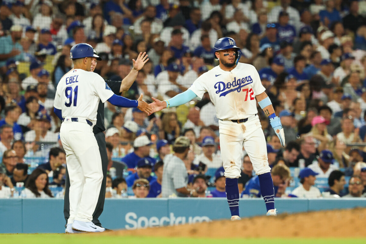 Jul 2, 2026; Los Angeles, California, USA; Los Angeles Dodgers shortstop Miguel Rojas (72) at third base with Los Angeles Dodgers third base coach/outfield coach Dino Ebel (91) at the booth of the fat Dodger Stadium. Mandatory Credit: William Navarro-Imagn Images