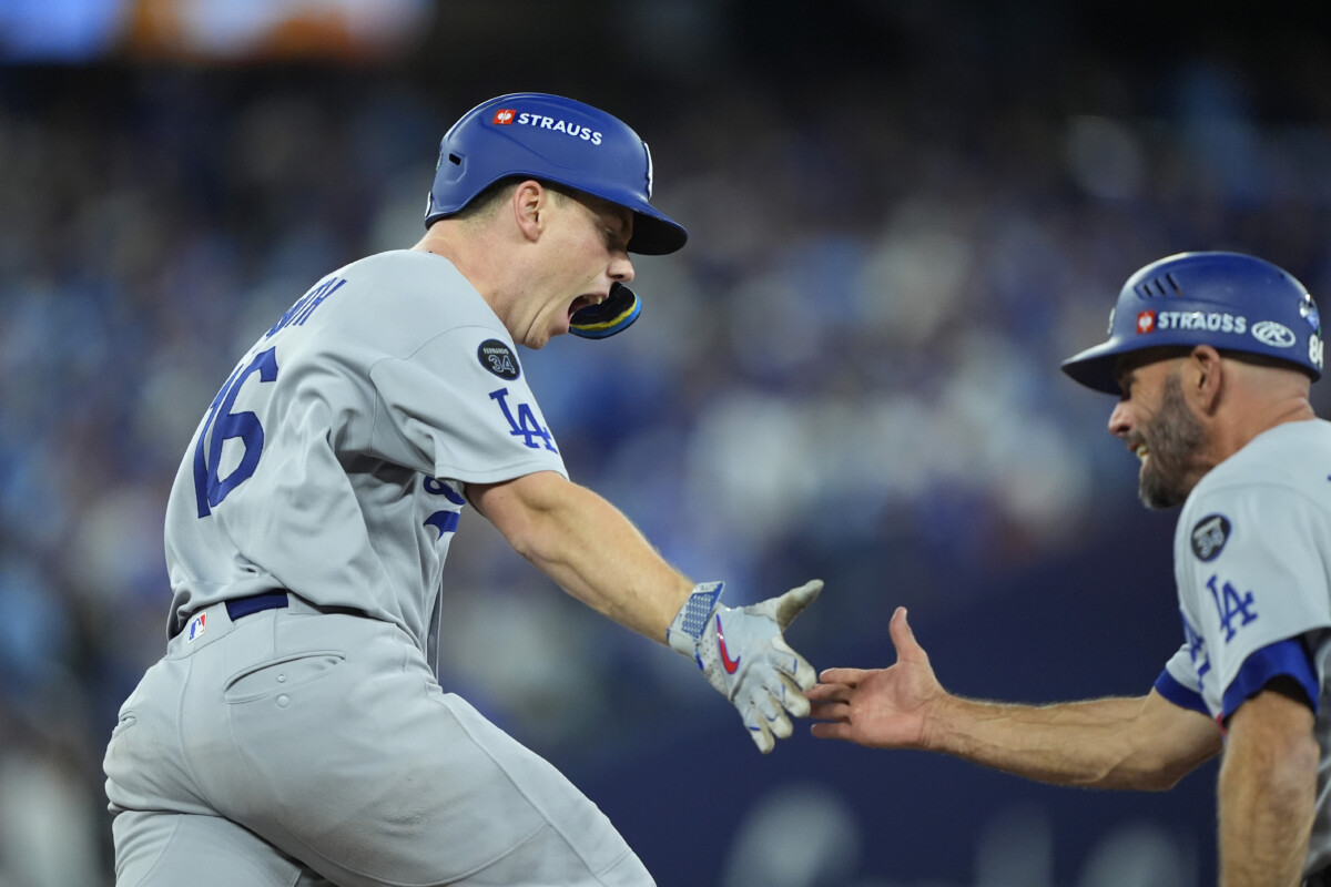 Nov 1, 2025; Toronto, Ontario, CAN; Los Angeles Dodgers catcher Will Smith (16) celebrates with first base coach/infield coach Chris Woodward (84) after hitting a home run against the Toronto Blue Jays in the eleventh inning during game seven of the 2025 MLB World Series at Rogers Centre. Mandatory Credit: John E. Sokolowski-Imagn Images