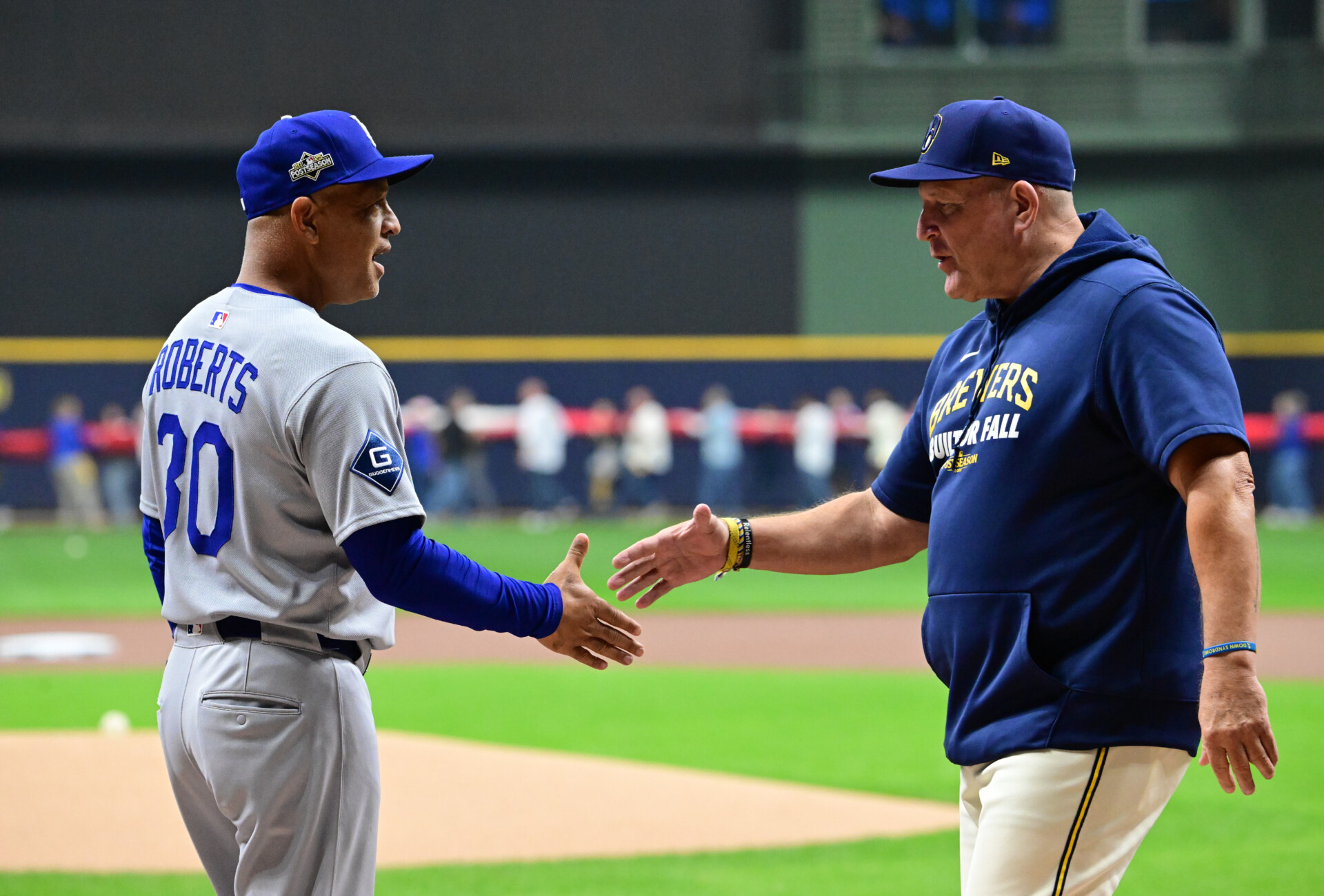 Oct 13, 2025; Milwaukee, Wisconsin, USA; Los Angeles Dodgers manager Dave Roberts (30) greets Milwaukee Brewers manager Pat Murphy (49) prior to game one of the NLCS round for the 2025 MLB playoffs at American Family Field. Mandatory Credit: Benny Sieu-Imagn Images