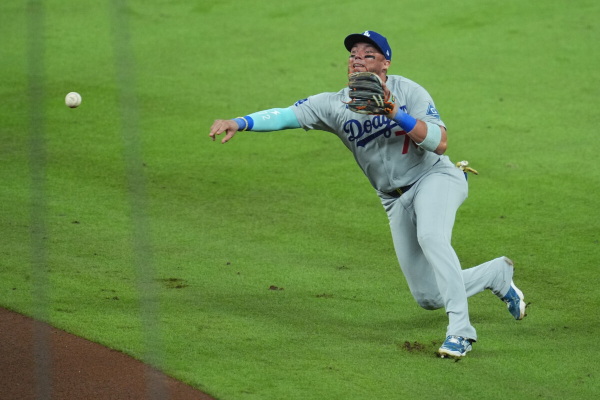 Oct 6, 2026; Cumberland, Georgia, USA;  Los Angeles Dodgers second baseman Miguel Rojas (72) throws to first base for an out against the Atlanta Braves in game three of the NLDS for the 2026 MLB Playoffs at Truist Park.  Mandatory Credit: Dale Zanine-Imagn Images