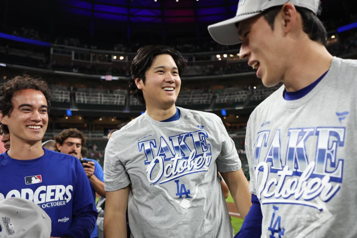 Oct 7, 2026; Cumberland, Georgia, USA; Los Angeles Dodgers pitcher Shohei Ohtani (17) and pitcher Roki Sasaki (11) and interpreter Will Ireton, left, celebrate after defeating the Atlanta Braves in game four of the NLDS for the 2026 MLB Playoffs at Truist Park. Mandatory Credit: Brett Davis-Imagn Images